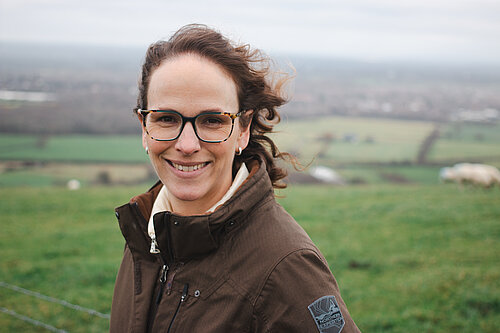 Alison on hills with fields in background