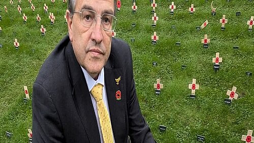 Martin Wrigley kneeling at a remembrance field